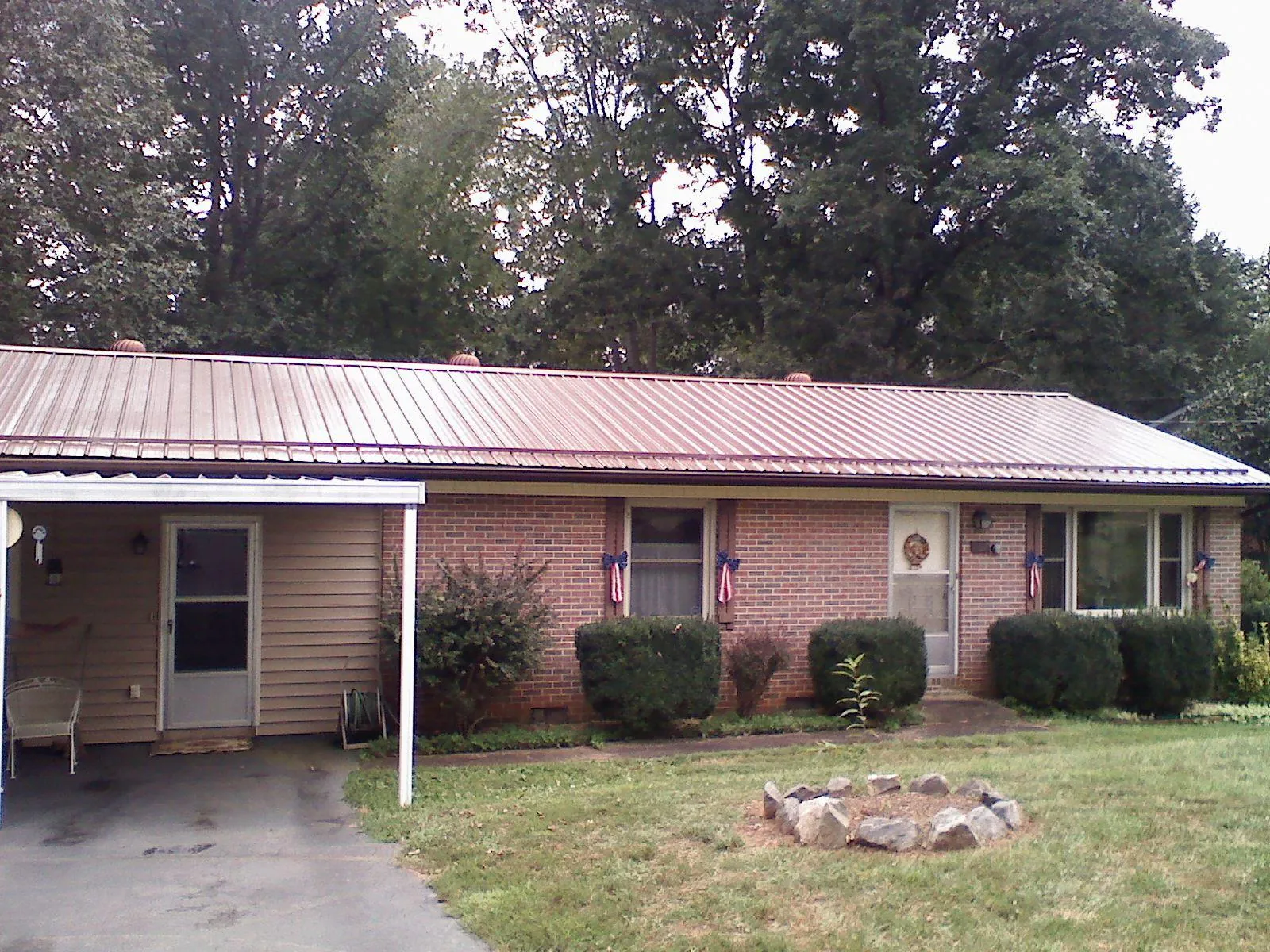 Bronze metal roof and carport on a brick ranch home — Roof Repair work by our crew in Mc Arthur